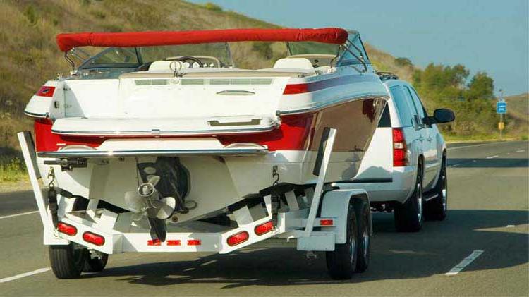 Vehicle towing a boat on a trailer safely.