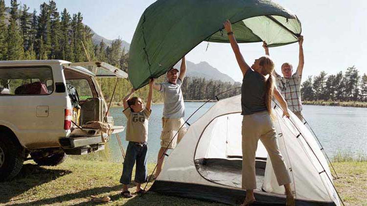 Family setting up a tent for camping.