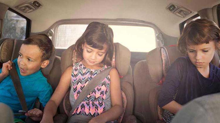 Kids in the back seat of a car.