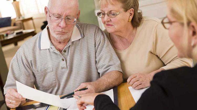 Older couple looking over paperwork with a younger woman.