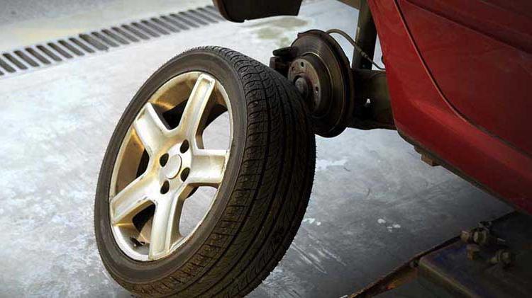 A car tire is removed to show the brakes underneath.