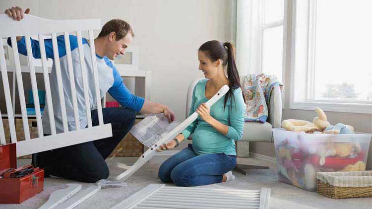 Couple practices crib safety while assembling baby's first crib.