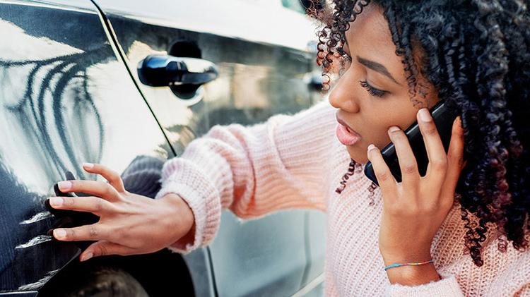 Woman calling her insurance company to report vehicle damage.