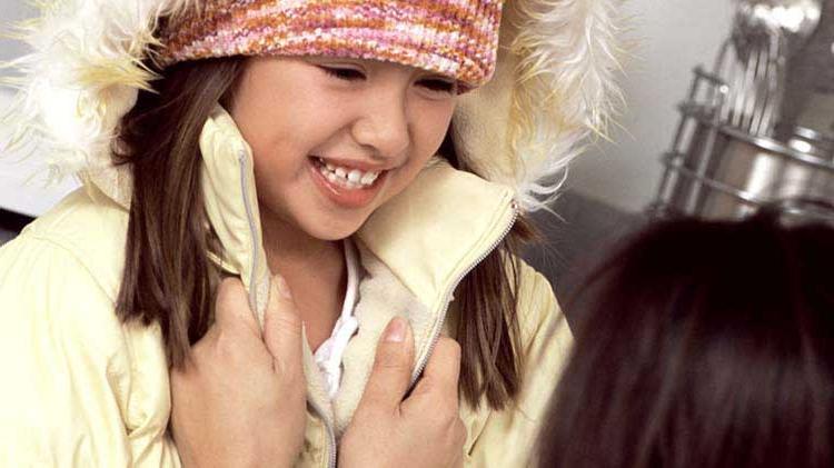 孩子穿着暖和的外套和帽子，以防止体温过低.