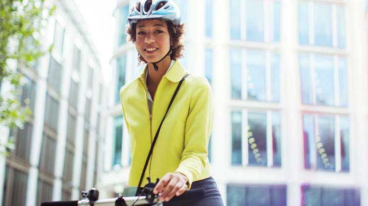A woman going to work by bicycle and with a helmet on her head