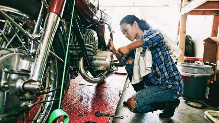Woman working on a motorcycle in a garage