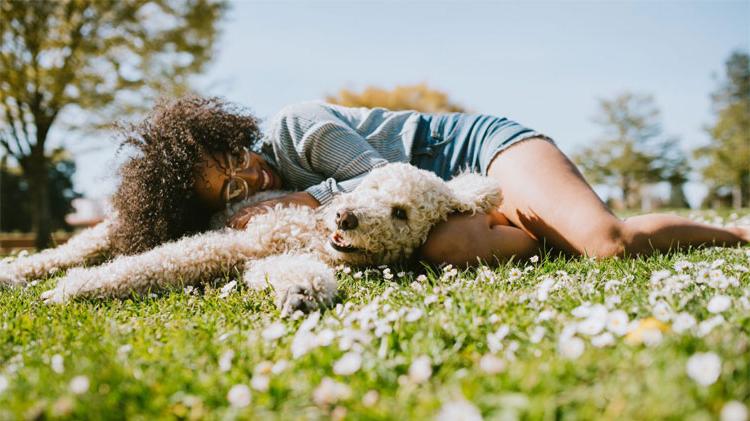 Woman cuddling and enjoying time with her dog at the park.