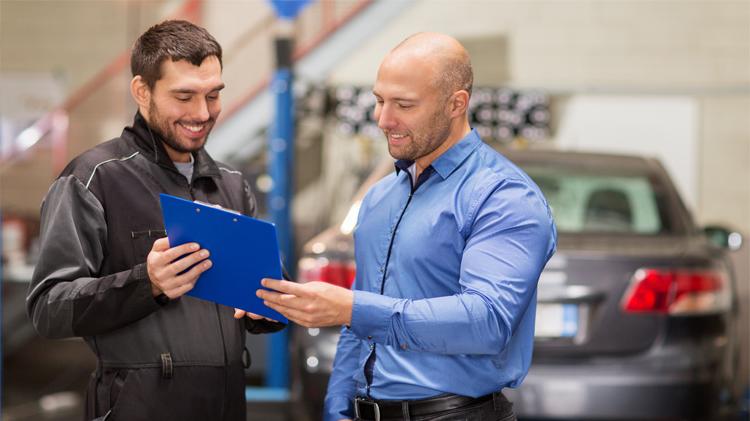 Mechanic with customer discussing car repair