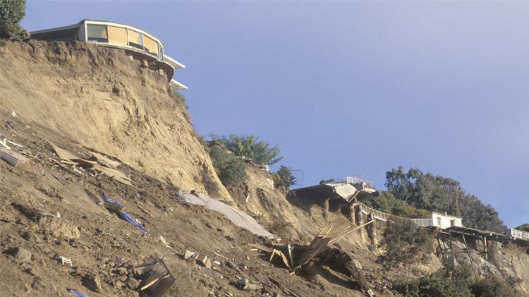 Earthquake damage to homes on a high ridge.