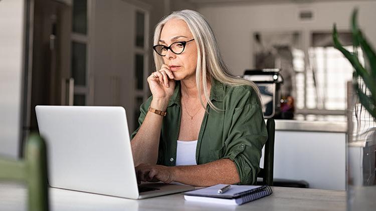 Woman sits in front of laptop, reviewing her estate plan.